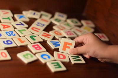 Cropped image of child holding toy blocks on table
