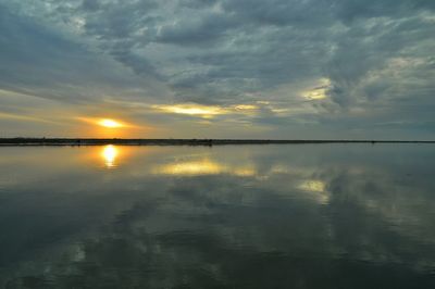 Scenic view of sea against cloudy sky at sunset