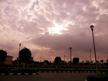 City street against cloudy sky at sunset