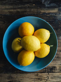 Directly above shot of meyer lemons in bowl on wooden table