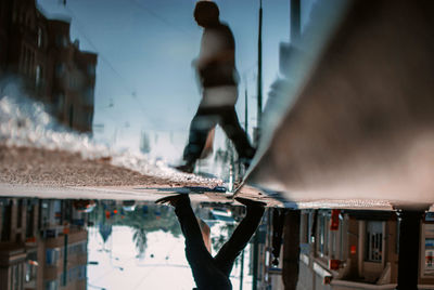 Person walking by puddle on road