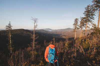 Active hiker enjoys the feeling of reaching the top of the mountain at sunrise