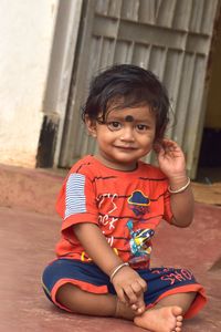 Portrait of cute boy sitting outdoors