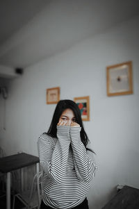 Young woman using mobile phone at home