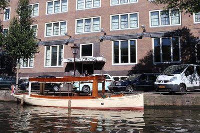 Boats moored in canal by buildings in city