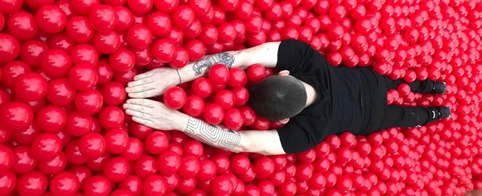 Full length of man lying in ball of pool