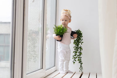 Girl looking away holding plant