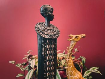 Close-up of statue against red wall