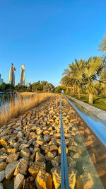 Surface level of road against clear blue sky