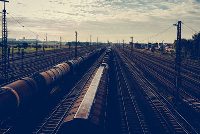 Freight trains on railroad tracks against sky during sunset