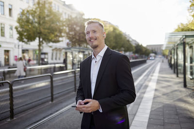 Businessman waiting at tram stop