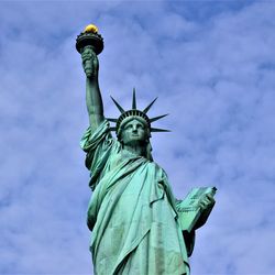 Low angle view of statue of liberty against sky