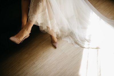 Low section of woman bride standing on hardwood floor
