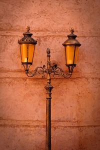 Illuminated street light against building wall