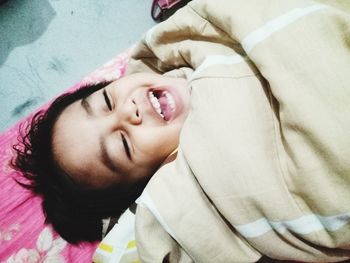 Portrait of smiling boy lying on bed