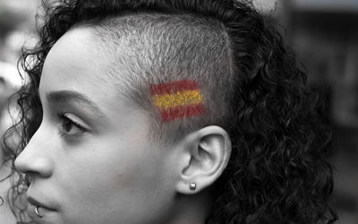 Close-up woman with spanish flag painted on head