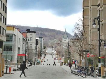 People walking on road amidst buildings in city