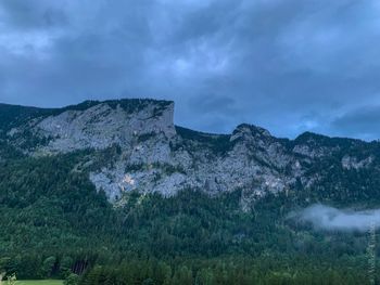 Scenic view of land and mountains against sky