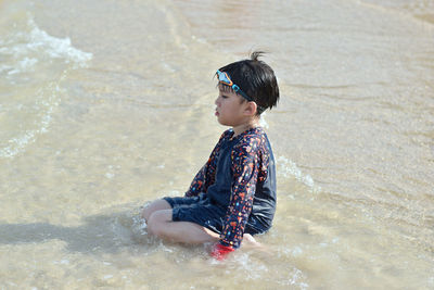 Rear view of boy on beach