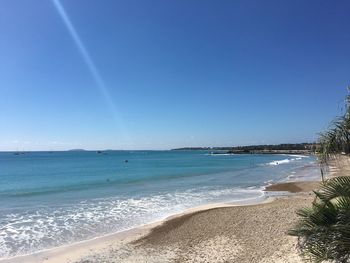 Scenic view of beach against blue sky