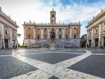 Statue in city against sky