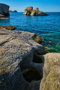 Rock formation on beach against sky