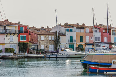 Boats moored at harbor against clear sky