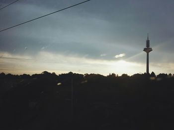 Silhouette of communications tower at dusk