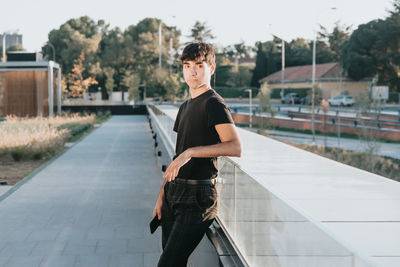 Portrait of young man standing on road