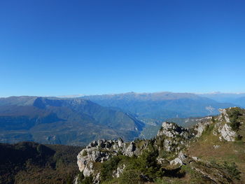 Scenic view of mountains against clear blue sky