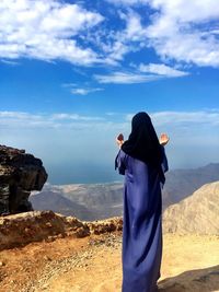 Rear view of man standing against sky