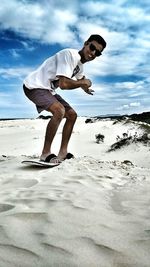 Full length of man standing on beach against sky