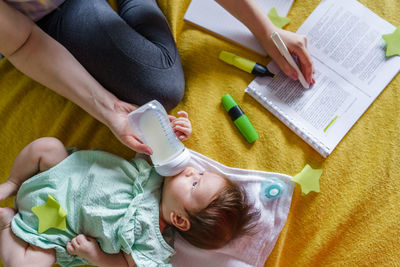 High angle view of cute girl drawing on book