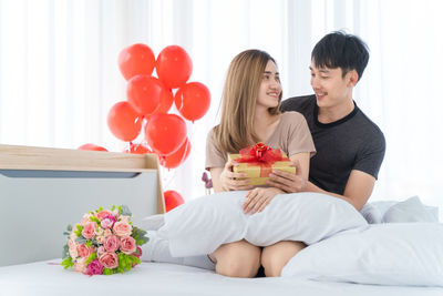 Young couple kissing against white wall