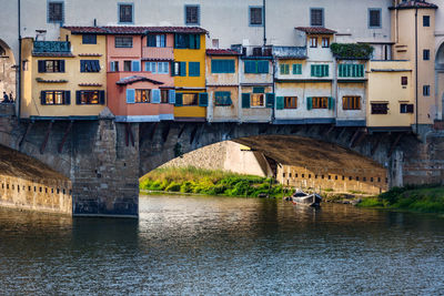 Bridge over river in city against sky