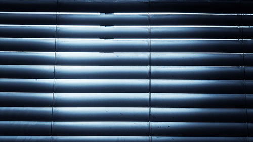 Full frame shot of patterned white  window blinds at twilight in doors