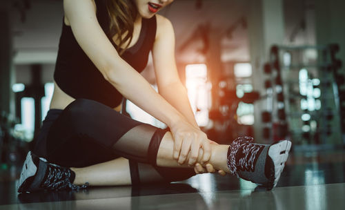 Young woman suffering from joint pain while exercising in gym