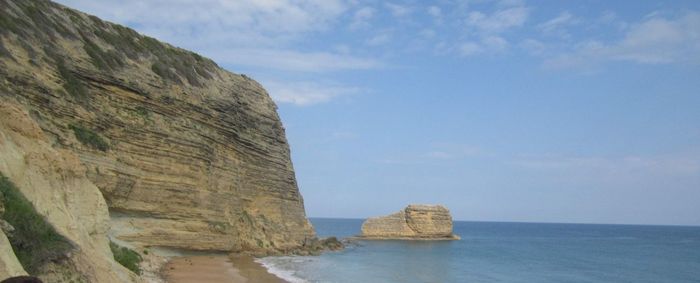 Rock formations by sea against sky