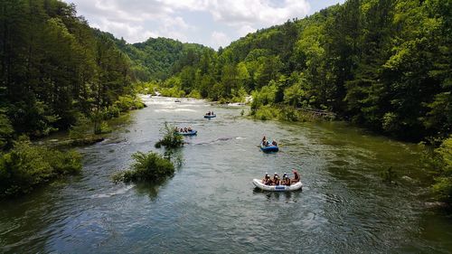 High angle view of people rafting in river amidst forest