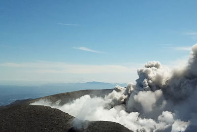Smoke emitting from volcanic mountain against sky