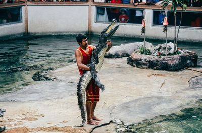 Full length of man standing on water against building