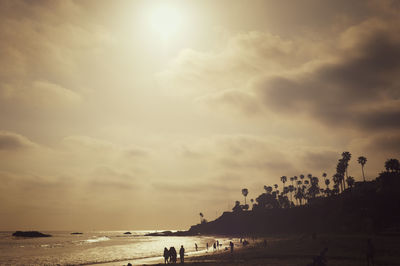 Tourists enjoying at beach during sunset