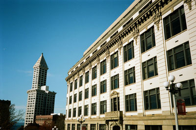 Low angle view of buildings against clear blue sky