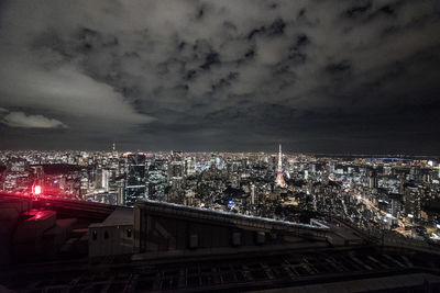 Illuminated cityscape against cloudy sky