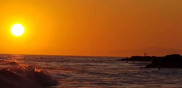 Scenic view of sea against orange sky