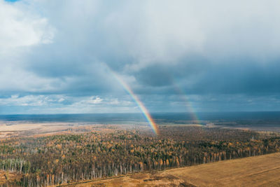 Scenic view of field against rainbow in sky