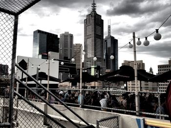 Modern buildings in city against cloudy sky