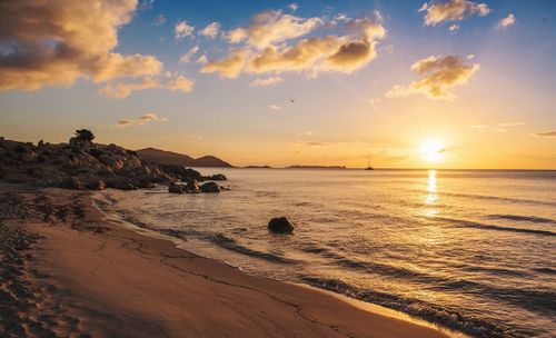 Scenic view of beach against sky during sunset