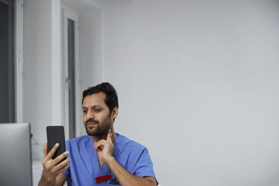 Male doctor having online consultation on smart phone