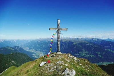 Cross on mountain against blue sky